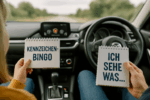Ein Kind und ein Erwachsener lachen gemeinsam während einer Autofahrt, ohne digitale Geräte zu nutzen.