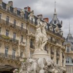 „Historische Gebäude und Brunnenstatue am Place de la Comédie in Montpellier, Frankreich.“