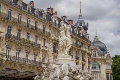 „Historische Gebäude und Brunnenstatue am Place de la Comédie in Montpellier, Frankreich.“