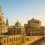 Fotorealistische Ansicht der Dresdner Altstadt mit Frauenkirche, Semperoper, Zwinger und Elbufer im warmen Sonnenlicht unter blauem Himmel.