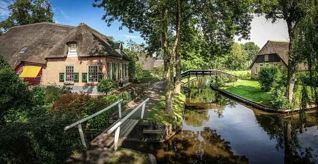 Malerisches Dorf Giethoorn in Holland mit reetgedeckten Häusern, kleinen Holzbrücken und idyllischem Kanal im Sonnenschein