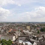 Panoramablick über Maastricht in den Niederlanden mit historischen Gebäuden, Kirchtürmen und der Maas im Hintergrund unter leicht bewölktem Himmel
